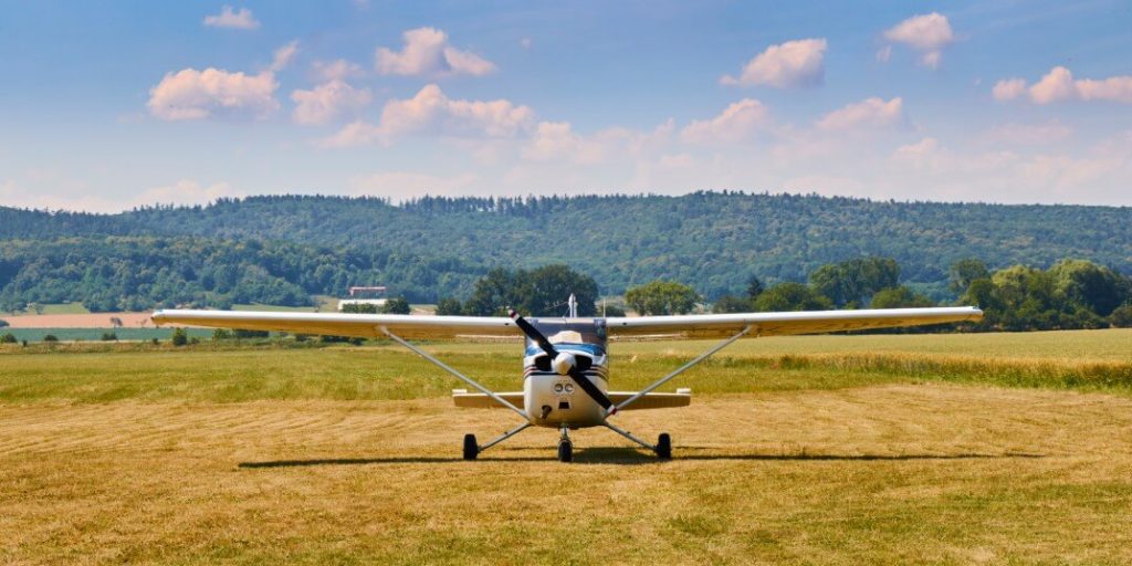 Front view of Cessna 172 airplane on a grass field